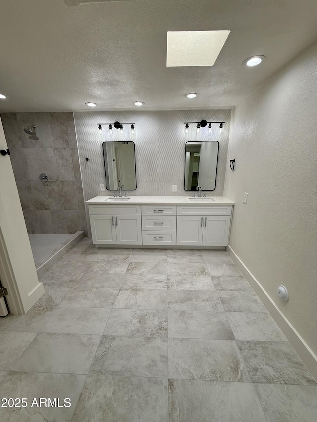 bathroom featuring vanity, a skylight, and tiled shower