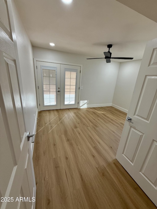 unfurnished room with ceiling fan, light hardwood / wood-style flooring, and french doors