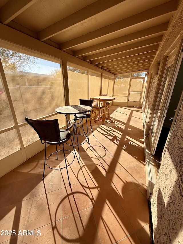 sunroom featuring beamed ceiling