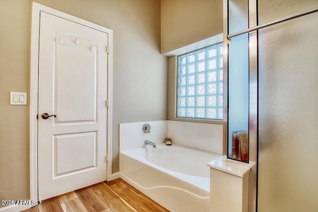 bathroom with wood-type flooring and a tub