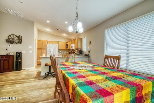 dining space with lofted ceiling and light hardwood / wood-style floors