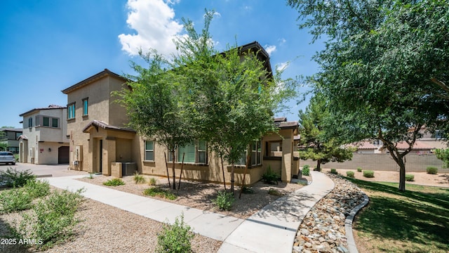 14870 W Encanto Blvd Unit 1059, Goodyear, AZ 85395 - view of front facade with stucco siding, cooling unit, and a garage