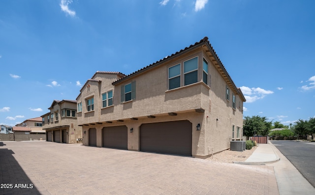 14870 W Encanto Blvd Unit 1059, Goodyear, AZ 85395 - view of front of home with stucco siding, central air condition unit, a garage, and driveway
