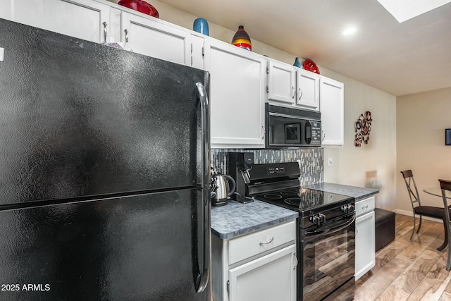 kitchen featuring black appliances, light wood-type flooring, white cabinets, and decorative backsplash