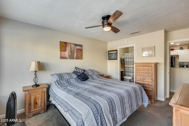 bedroom with ensuite bath, a textured ceiling, ceiling fan, and dark carpet