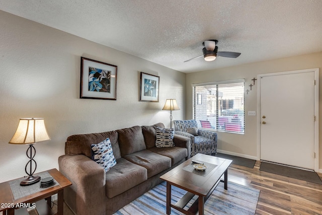 living room with a textured ceiling, ceiling fan, and hardwood / wood-style flooring