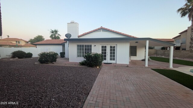 1044 N Arvada N, Mesa, AZ 85205 - view of front of property with french doors, a patio, a fenced backyard, a chimney, and a tile roof
