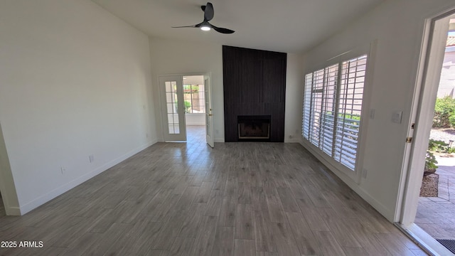 1044 N Arvada N, Mesa, AZ 85205 - unfurnished living room featuring a ceiling fan, a fireplace, wood finished floors, and vaulted ceiling