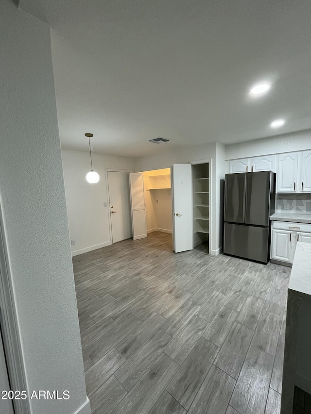 1044 N Arvada N, Mesa, AZ 85205 - kitchen featuring freestanding refrigerator, white cabinets, light countertops, and light wood finished floors