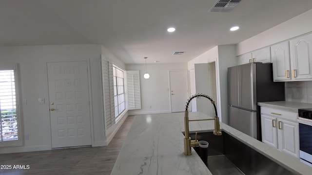 1044 N Arvada N, Mesa, AZ 85205 - kitchen with freestanding refrigerator, white cabinetry, healthy amount of natural light, pendant lighting, and recessed lighting