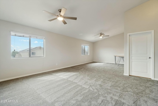 unfurnished room featuring carpet, vaulted ceiling, baseboards, and ceiling fan