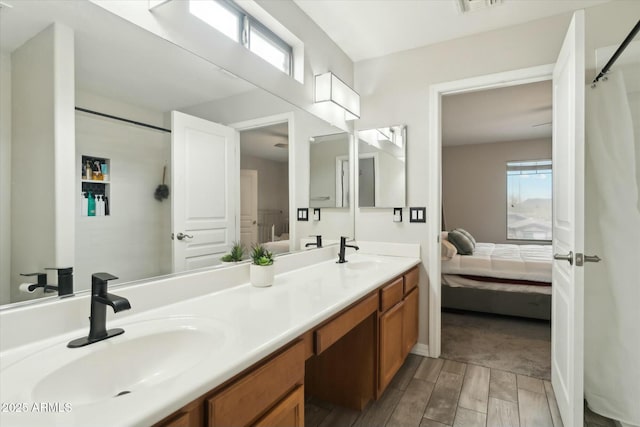 ensuite bathroom featuring wood finish floors, double vanity, a sink, and ensuite bathroom