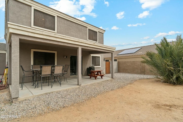 back of house featuring a patio area, a fenced backyard, outdoor dining area, and stucco siding