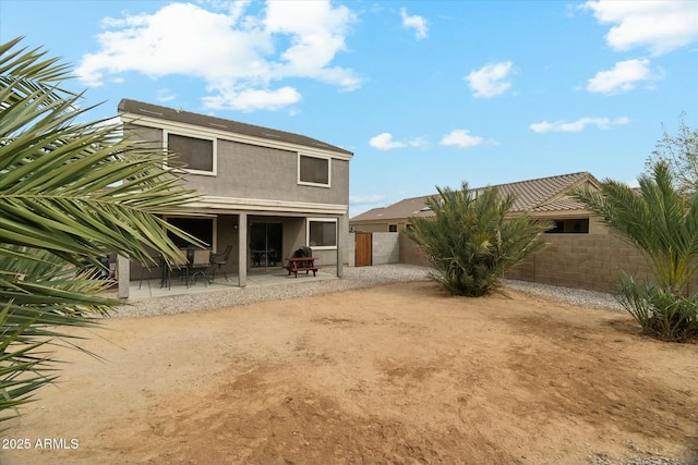 rear view of house with a patio area, a fenced backyard, and stucco siding