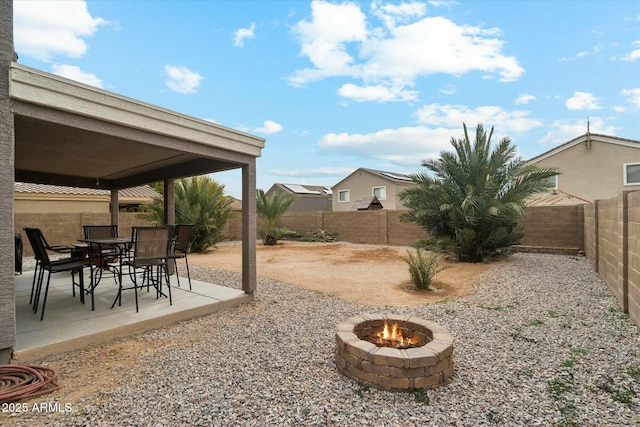 view of yard with an outdoor fire pit, outdoor dining area, a patio area, and a fenced backyard