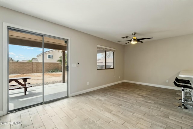 unfurnished room featuring light wood-style flooring, baseboards, and a wealth of natural light