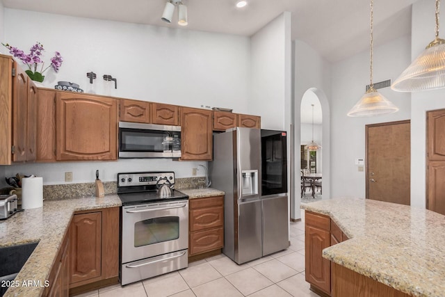 9414 S La Rosa Dr, Tempe, AZ 85284 - kitchen with stainless steel appliances, high vaulted ceiling, arched walkways, light tile patterned floors, and pendant lighting