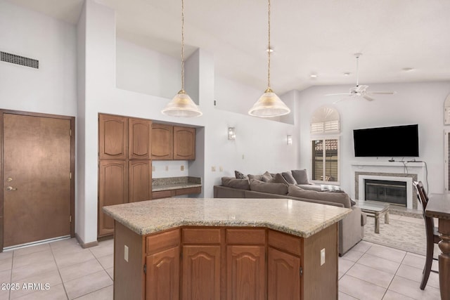 9414 S La Rosa Dr, Tempe, AZ 85284 - kitchen featuring light tile patterned floors, a ceiling fan, a glass covered fireplace, light countertops, and high vaulted ceiling