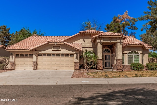 9414 S La Rosa Dr, Tempe, AZ 85284 - mediterranean / spanish home featuring stone siding, an attached garage, driveway, and stucco siding