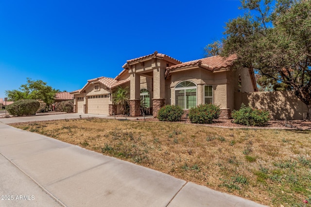 9414 S La Rosa Dr, Tempe, AZ 85284 - mediterranean / spanish-style home featuring a tile roof, a garage, stucco siding, driveway, and stone siding