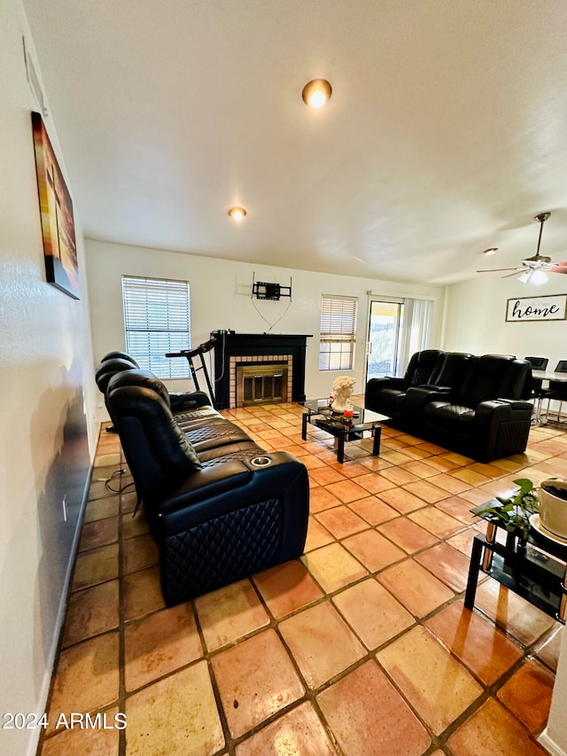 tiled living room with a fireplace and ceiling fan