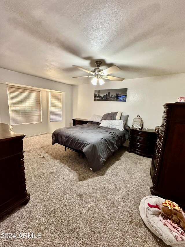 carpeted bedroom featuring a textured ceiling and ceiling fan