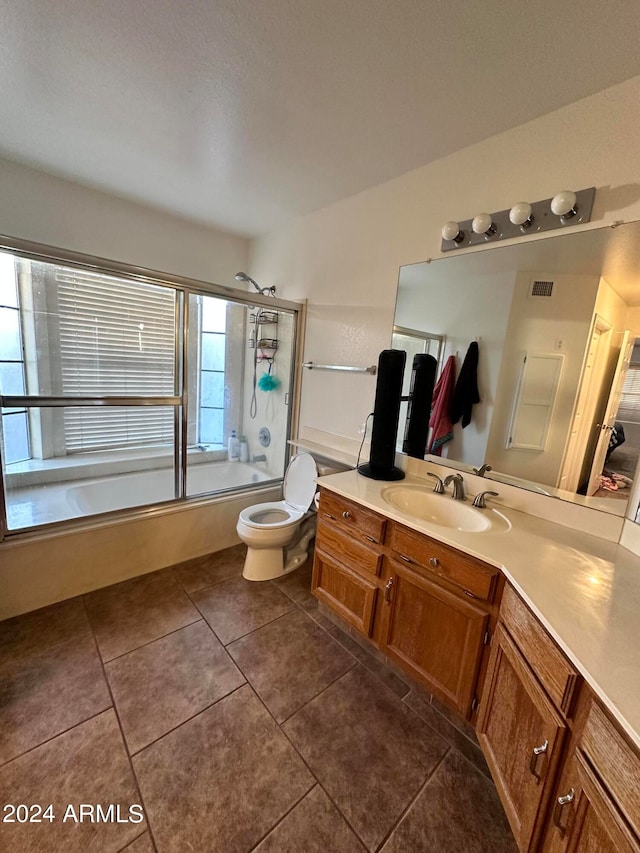 full bathroom featuring vanity, tile patterned floors, toilet, and combined bath / shower with glass door