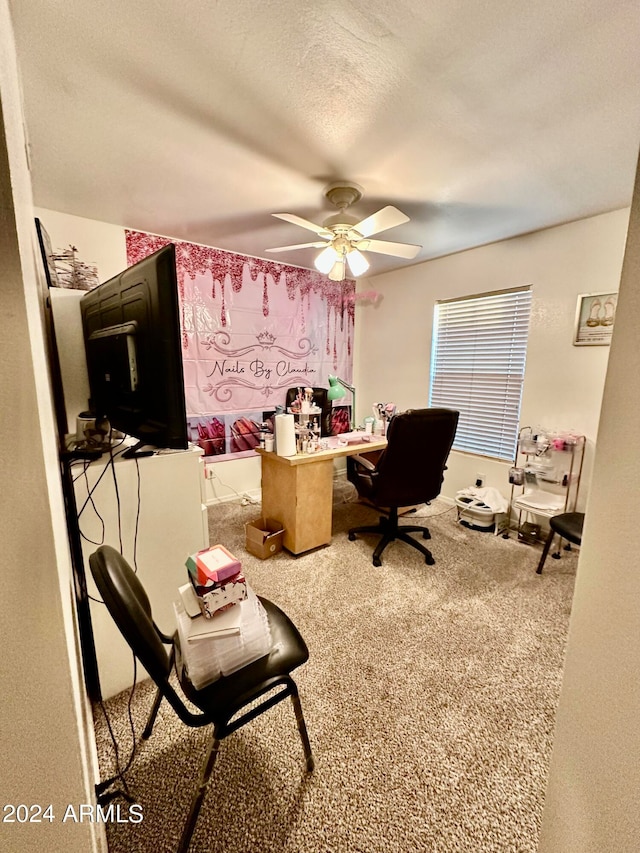 carpeted office featuring ceiling fan and a textured ceiling