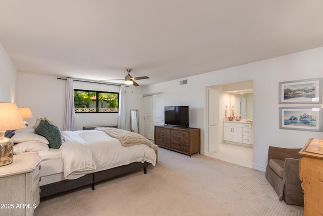 bedroom featuring connected bathroom, a closet, light carpet, ceiling fan, and visible vents