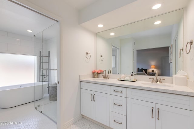ensuite bathroom featuring double vanity, a sink, a shower stall, and ensuite bath