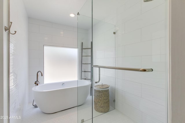 full bathroom with tiled shower, tile patterned floors, a freestanding bath, and tile walls