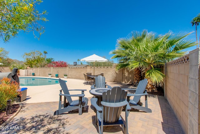 view of patio / terrace with an outdoor fire pit, a fenced backyard, and a fenced in pool