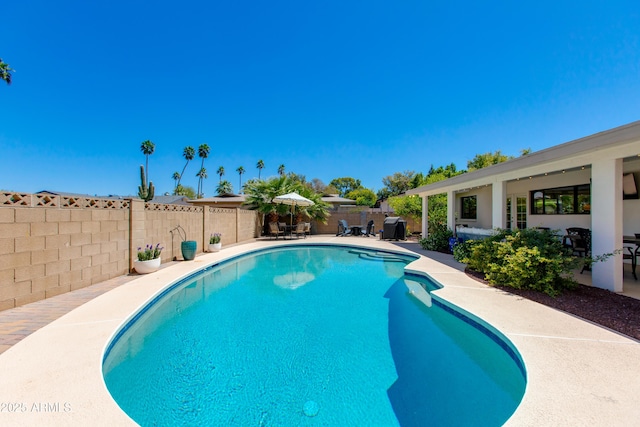 view of swimming pool with a fenced backyard, a fenced in pool, and a patio area