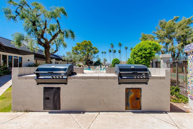view of patio / terrace with an outdoor kitchen, grilling area, and fence
