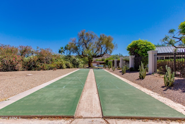 view of property's community featuring shuffleboard and fence