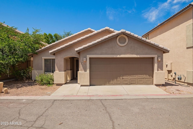 125 N 22nd Pl Unit 53, Mesa, AZ 85213 - view of front facade featuring stucco siding, a garage, a tiled roof, and driveway