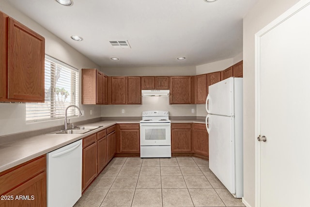 125 N 22nd Pl Unit 53, Mesa, AZ 85213 - kitchen with white appliances, a sink, under cabinet range hood, light tile patterned floors, and brown cabinetry