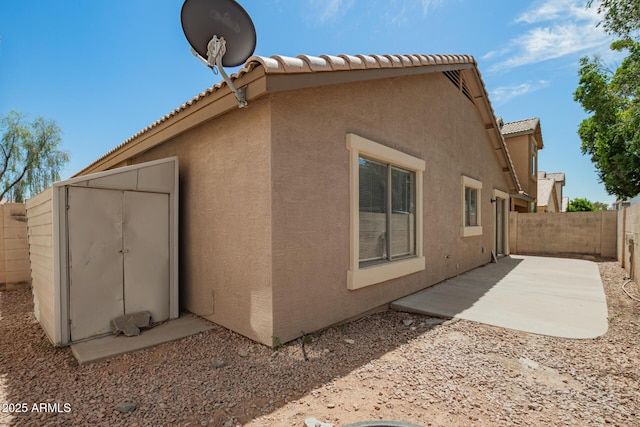 125 N 22nd Pl Unit 53, Mesa, AZ 85213 - view of property exterior featuring stucco siding, a fenced backyard, a patio, and a tiled roof