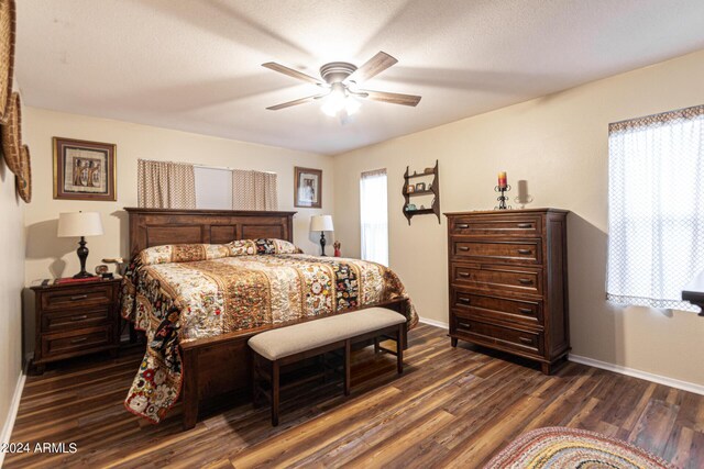 bedroom featuring ceiling fan, a textured ceiling, ensuite bathroom, and dark hardwood / wood-style flooring