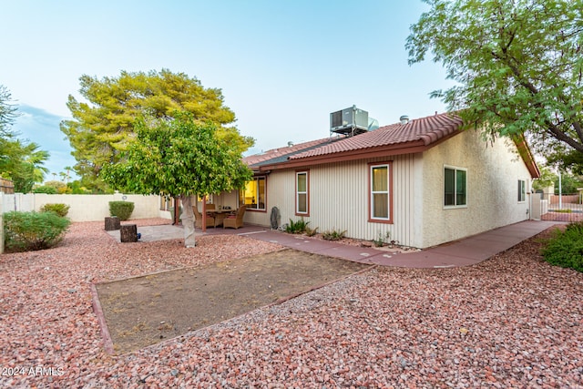 rear view of house featuring a patio and central AC