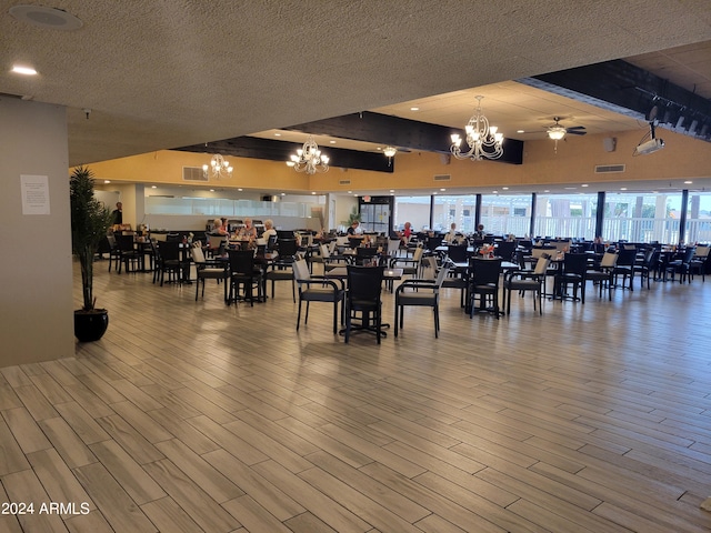 dining space with a textured ceiling, beamed ceiling, hardwood / wood-style floors, and ceiling fan