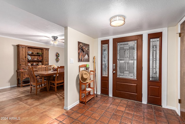 tiled foyer featuring a textured ceiling and ceiling fan