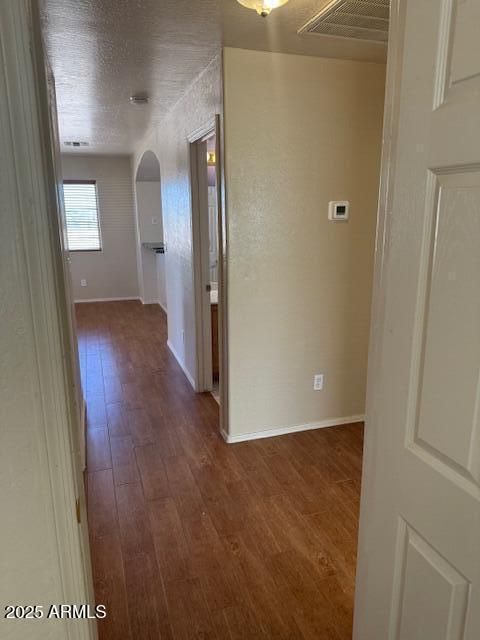 5122 E Shadow Ln, San Tan Valley, AZ 85140 - hallway featuring arched walkways, dark wood-type flooring, and baseboards