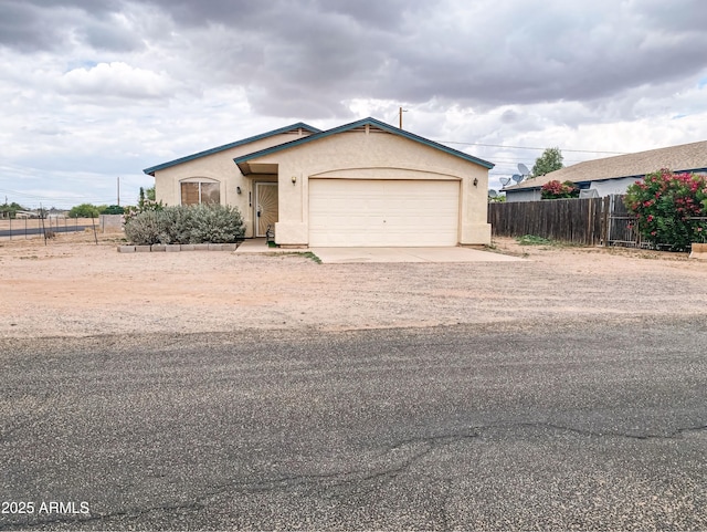 5122 E Shadow Ln, San Tan Valley, AZ 85140 - view of front of house with fence, stucco siding, dirt driveway, and an attached garage