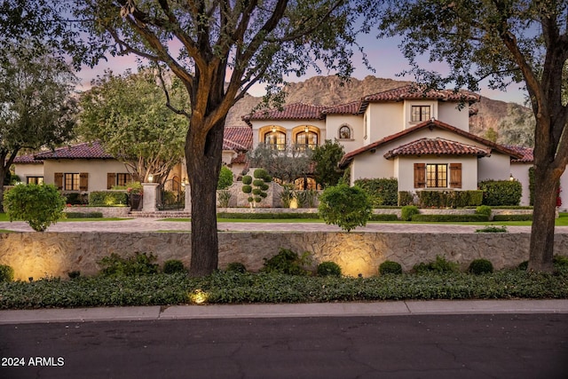 mediterranean / spanish home featuring stucco siding and a tiled roof