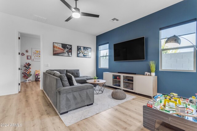 living room featuring light hardwood / wood-style floors, ceiling fan, and plenty of natural light