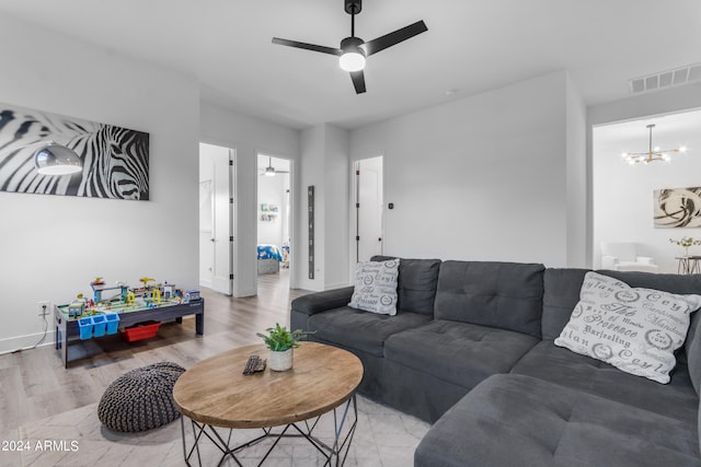 living room with ceiling fan with notable chandelier and wood-type flooring