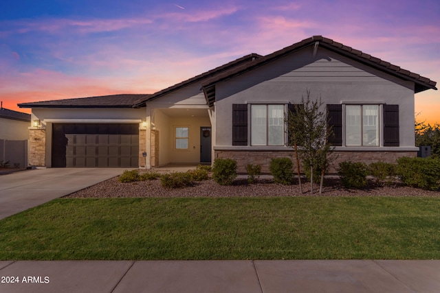 view of front of house with a garage and a lawn