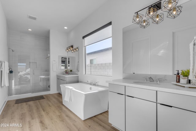 bathroom featuring vanity, separate shower and tub, and hardwood / wood-style floors