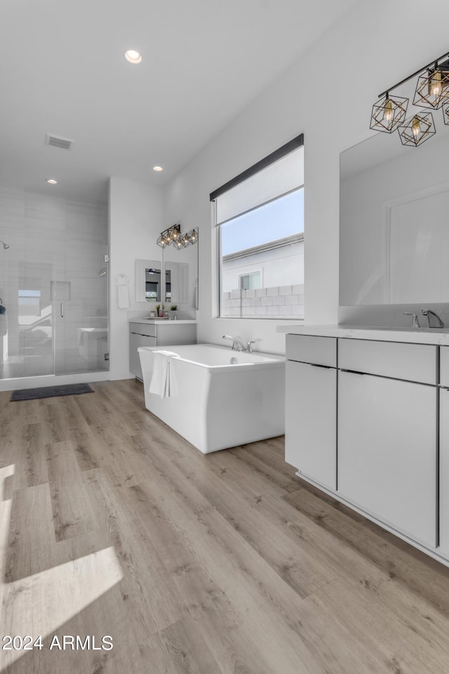 bathroom featuring vanity, shower with separate bathtub, and hardwood / wood-style floors